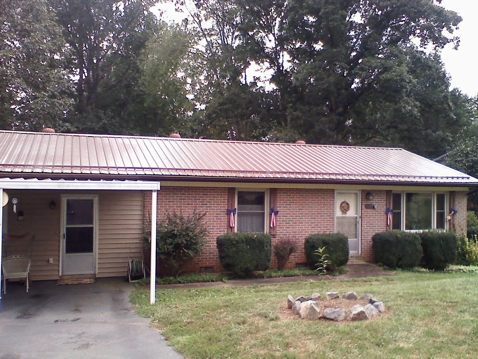 Bronze metal roof and carport on a brick ranch home in Hubbardston