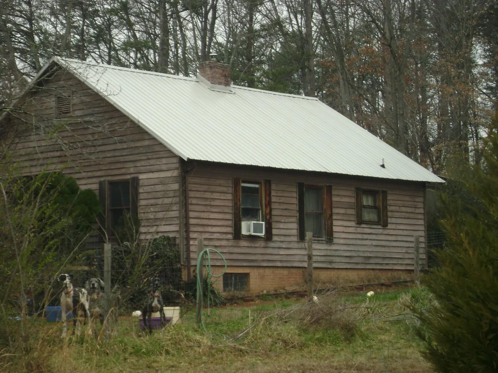 White metal roof on an old wood sided farmhouse, from a Metal Roof Installation job in Hubbardston
